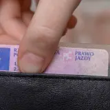 Dłoń wkłada prawo jazdy do portfela. Wkrótce czekają Cię badania lekarskie na prawo jazdy Poznań.