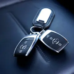 Dwa kluczyki Mercedesa na skórzanym siedzeniu. Zastanawiasz się, ile kosztuje kodowanie kluczyka?