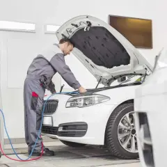 Mechanik sprawdza samochód, by dowiedzieć się, ile kosztuje przegląd rejestracyjny.