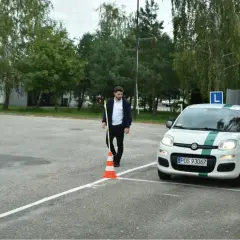 Egzaminator z pachołkiem obok białego auta z literą L. Zastanawiasz się, ile razy może zgasnąć auto na egzaminie?