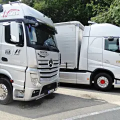 Ciężarówki z logo FIA Action for Road Safety. Szerokość samochodu osobowego jest znacznie mniejsza niż tych potężnych pojazdów.