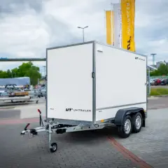 Biała przyczepa towarowa z logo UNITRAILER. Dowiedz się, jak zarejestrować przyczepę rolniczą samoróbkę.