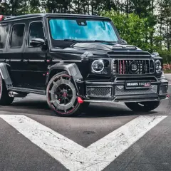 Czarny Brabus Rocket 900, czyli ile kosztuje Mercedes G klasa Brabus? Potężny SUV na tle lasu.