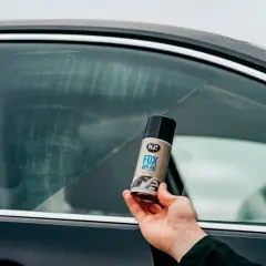 Dłoń trzyma puszkę K2 FOX ANTI-FOG, która zapobiega zaparowaniu szyb.