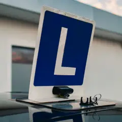 Tablica z literą "L" na dachu samochodu, symbolizująca naukę jazdy. Czy można zobaczyć nagranie z egzaminu na prawo jazdy?