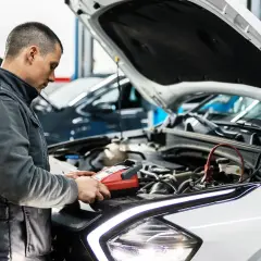 Mechanik sprawdza auto, by dowiedzieć się, ile trwa badanie techniczne pojazdu.