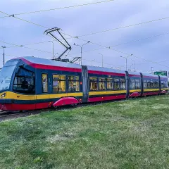 Nowoczesny tramwaj Pesa na torach, otoczony zielenią. Czy tramwaj ma zawsze pierwszeństwo? To pytanie zadaje sobie wielu kierowców.