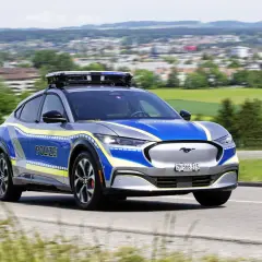 Policyjny Ford Mustang Mach-E z włączonymi sygnałami świetlnymi. Pamiętaj, kiedy można wyprzedzać pojazd uprzywilejowany.