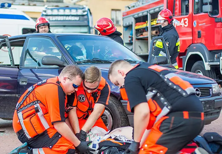 Ratownicy medyczni ćwiczą udzielanie pomocy poszkodowanemu po wypadku samochodowym. To jak wygląda egzamin KPP w praktyce.