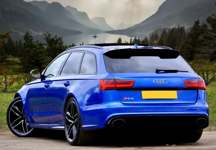 Błękitne Audi RS6 na tle górskiego krajobrazu. Zastanawiasz się, ile cło za samochód z Niemiec?