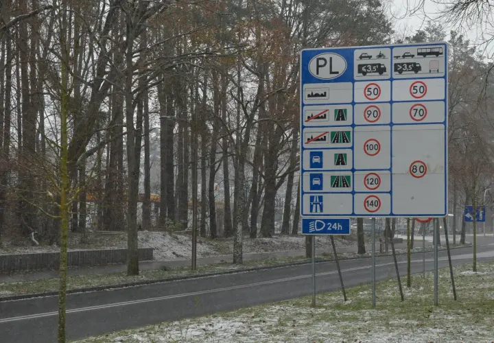 Znak drogowy PL informuje o ograniczeniach prędkości na drogach dwukierunkowych jednojezdniowych.