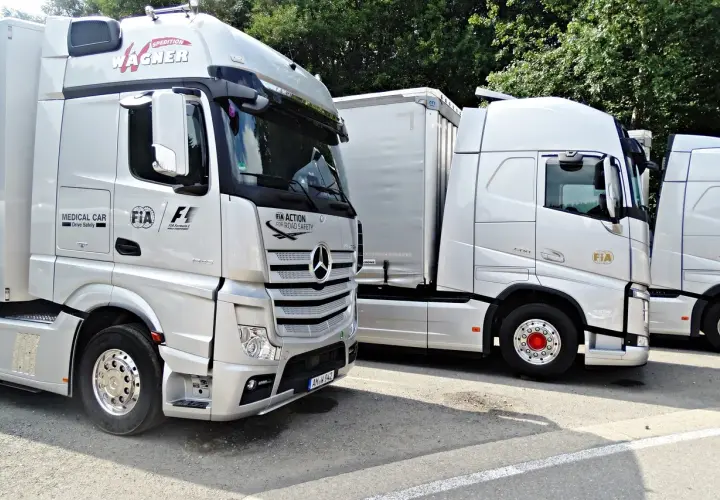 Ciężarówki z logo FIA Action for Road Safety. Szerokość samochodu osobowego jest znacznie mniejsza niż tych potężnych pojazdów.