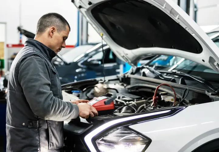 Mechanik sprawdza auto, by dowiedzieć się, ile trwa badanie techniczne pojazdu.
