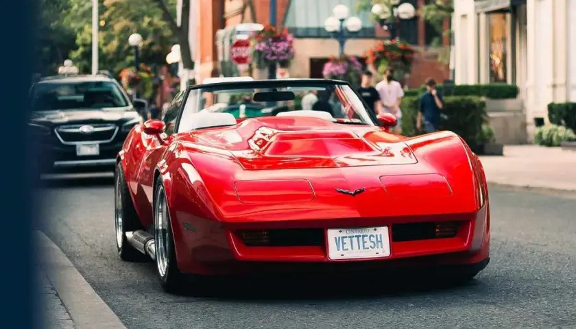 Czerwony Chevrolet Corvette na ulicy. Zastanawiasz się, ile wynosi cło z USA na samochód?
