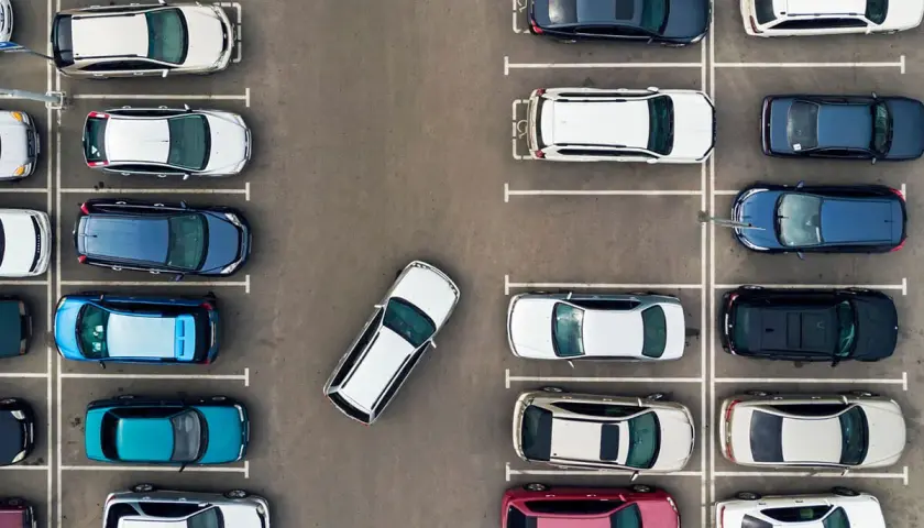Widok z góry na parking. Samochody ustawione prostopadle przodem. Kiedy skręcać, by zaparkować?