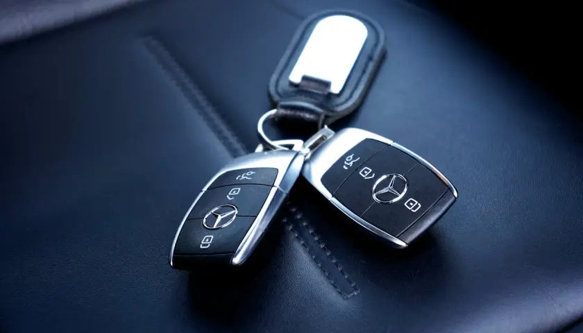 Dwa kluczyki Mercedesa na skórzanym siedzeniu. Zastanawiasz się, ile kosztuje kodowanie kluczyka?