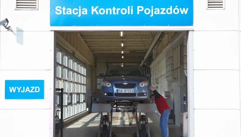 Pracownik sprawdza auto na podnośniku. Dowiedz się, ile kosztuje diagnostyka auta.