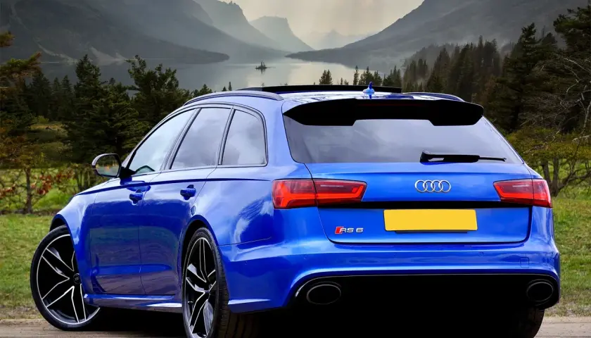 Błękitne Audi RS6 na tle górskiego krajobrazu. Zastanawiasz się, ile cło za samochód z Niemiec?