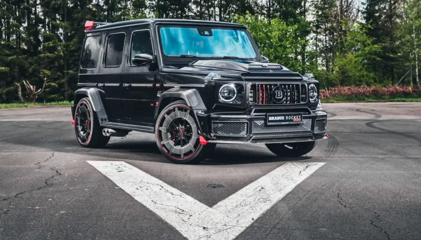 Czarny Brabus Rocket 900, czyli ile kosztuje Mercedes G klasa Brabus? Potężny SUV na tle lasu.