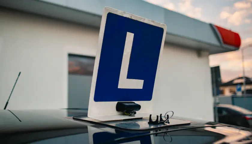 Tablica z literą "L" na dachu samochodu, symbolizująca naukę jazdy. Czy można zobaczyć nagranie z egzaminu na prawo jazdy?