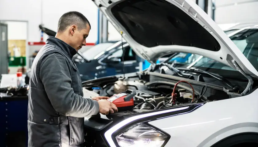 Mechanik sprawdza auto, by dowiedzieć się, ile trwa badanie techniczne pojazdu.