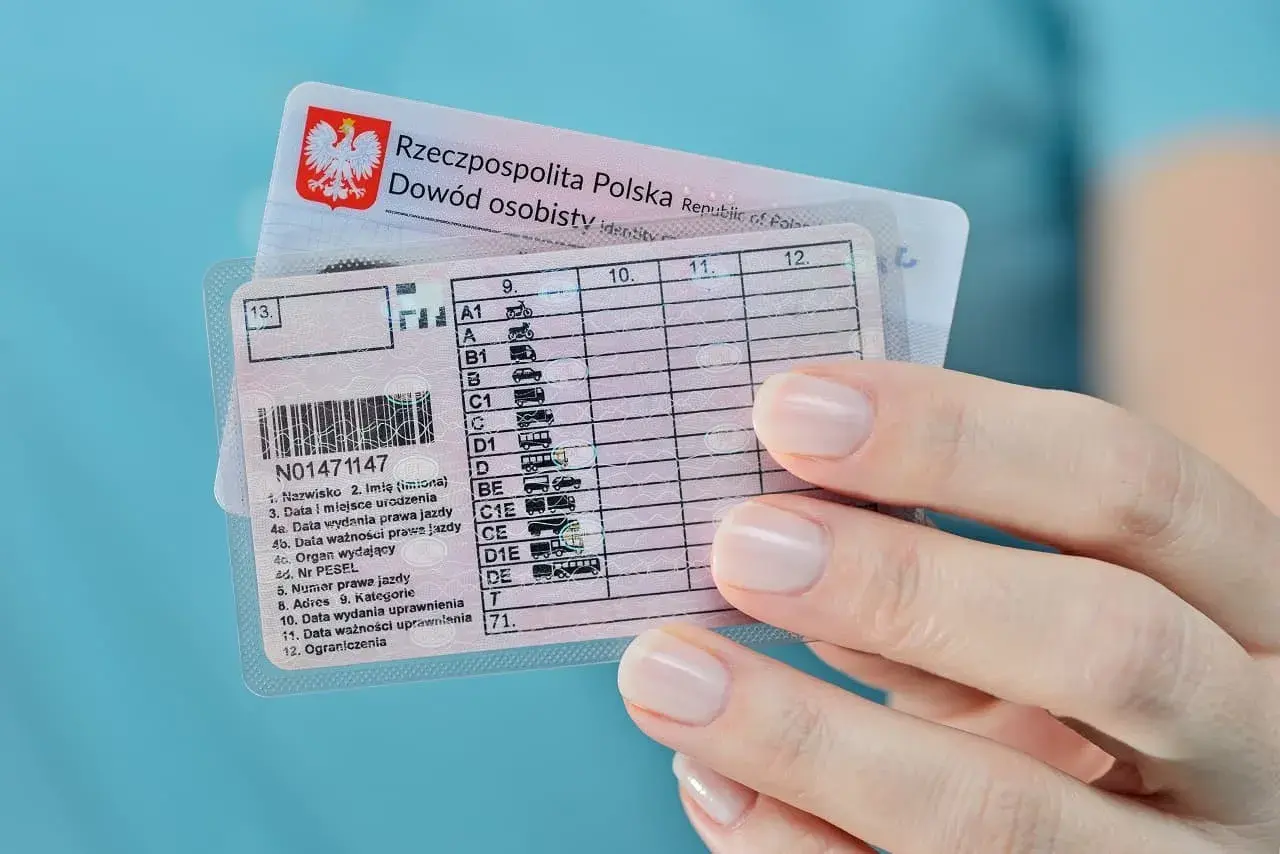 Dłoń trzyma polskie prawo jazdy i dowód osobisty. Teraz wiesz, co zrobić po zdaniu prawa jazdy!