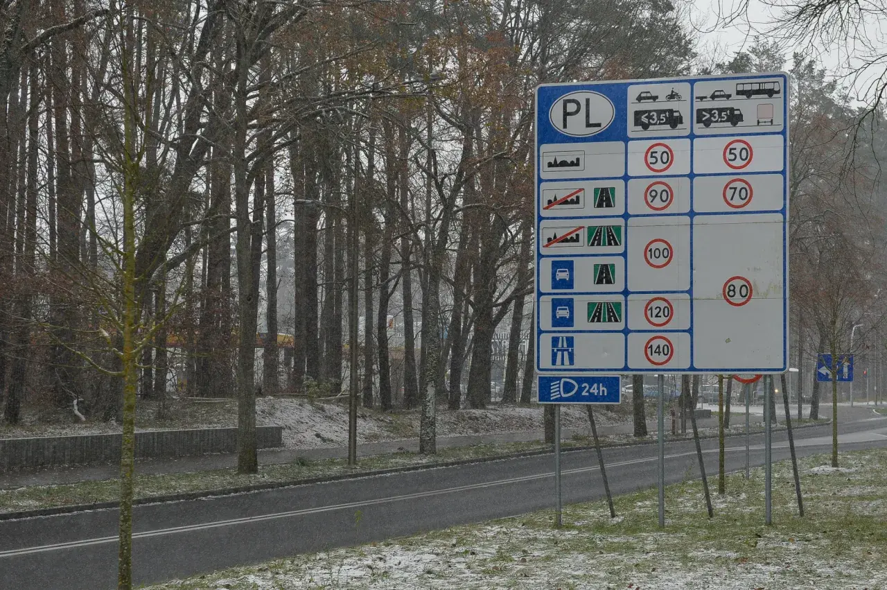 Znak drogowy PL informuje o ograniczeniach prędkości na drogach dwukierunkowych jednojezdniowych.