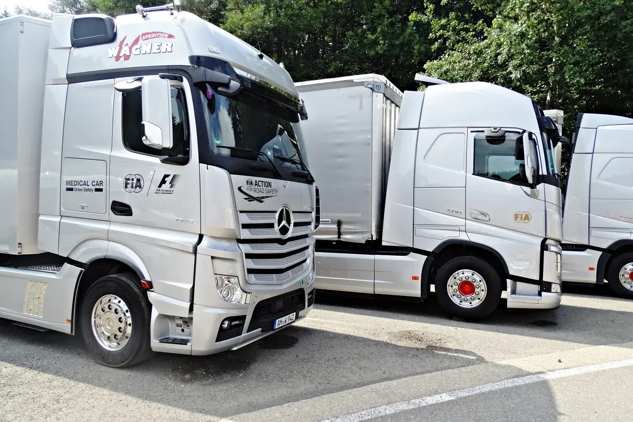 Ciężarówki z logo FIA Action for Road Safety. Szerokość samochodu osobowego jest znacznie mniejsza niż tych potężnych pojazdów.