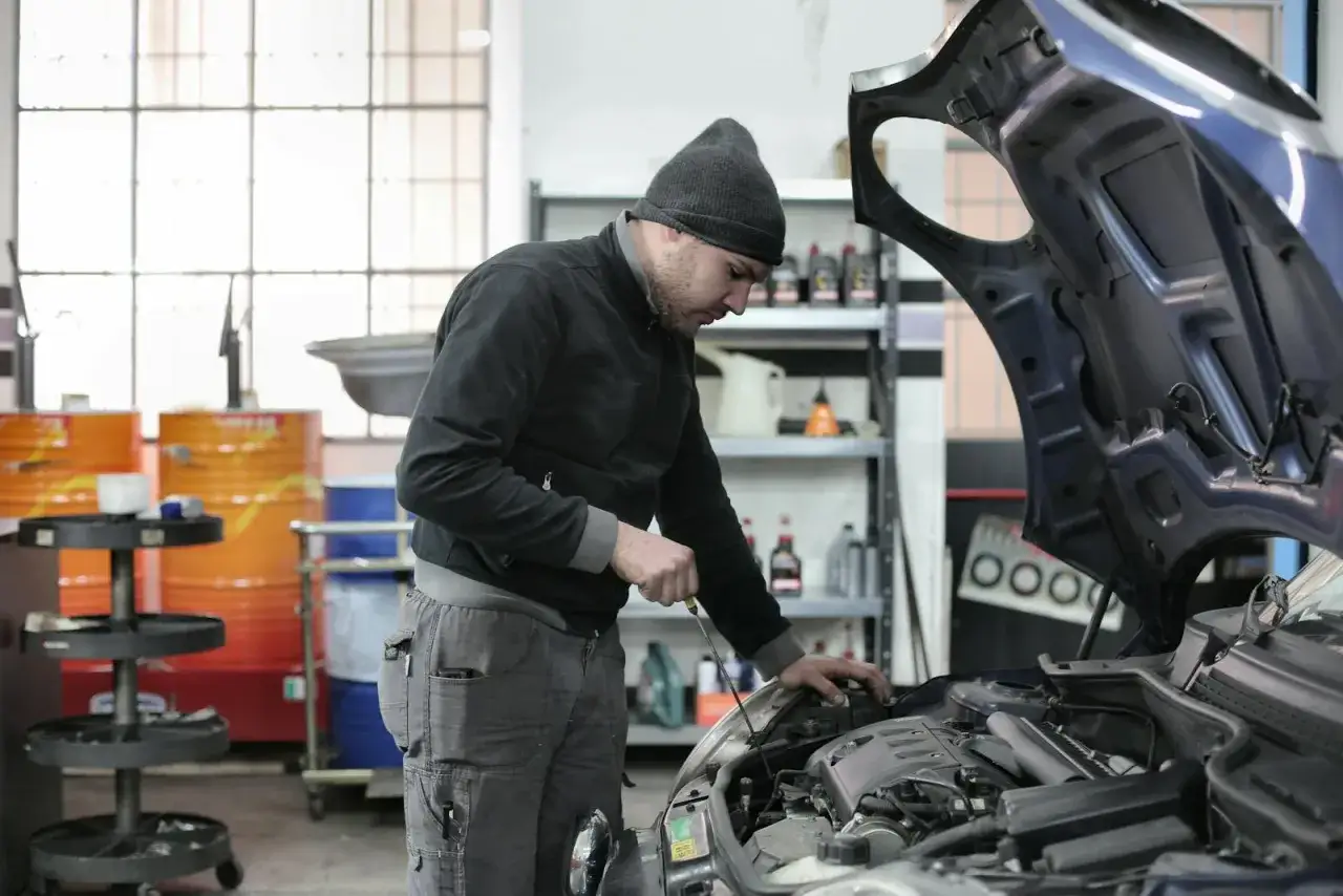 Mechanik samochodowy sprawdza silnik. Zastanawiasz się, ile zarabia mechanik samochodowy? Praca wymaga precyzji i wiedzy.