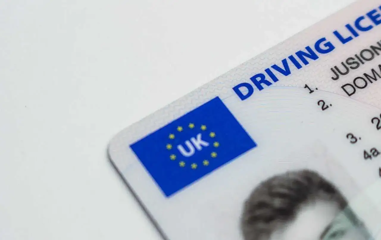Zbliżenie na brytyjskie prawo jazdy. Widoczny fragment z flagą UK i napisem 