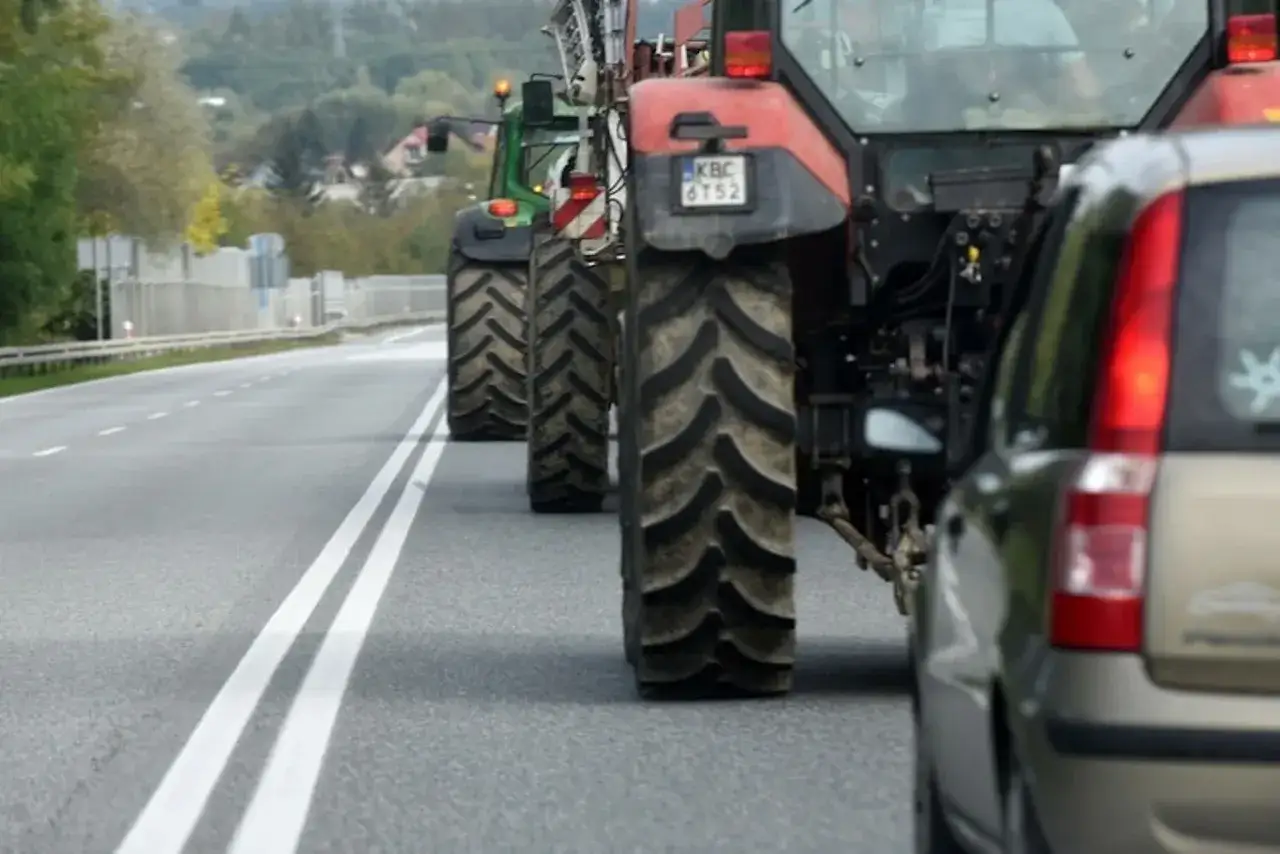 Kolejka traktorów na drodze. Czy traktorkiem kosiarka można jeździć po drodze? Tak, jeśli jest to maszyna rolnicza.