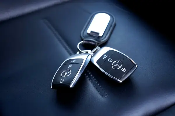 Dwa kluczyki Mercedesa na skórzanym siedzeniu. Zastanawiasz się, ile kosztuje kodowanie kluczyka?