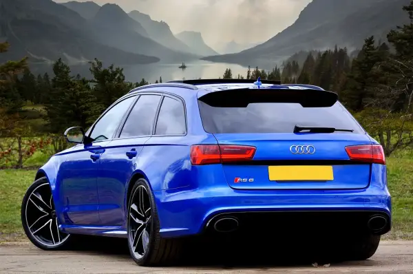 Błękitne Audi RS6 na tle górskiego krajobrazu. Zastanawiasz się, ile cło za samochód z Niemiec?